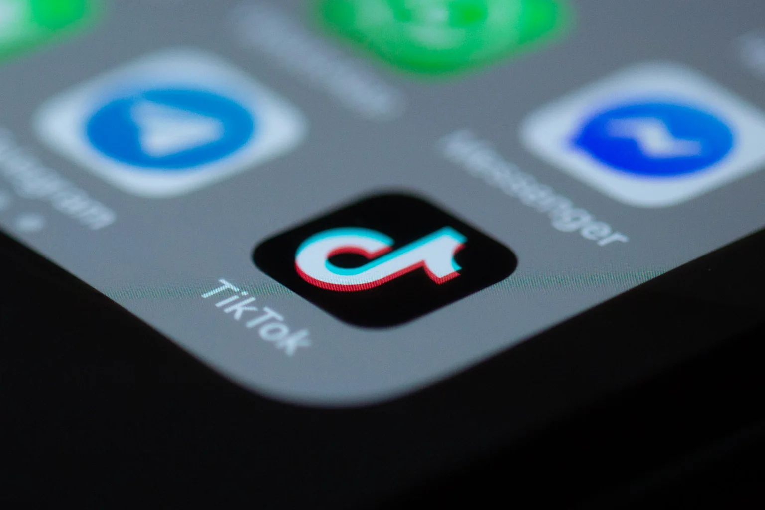 Close-up of a smartphone screen showing the TikTok app icon among other blurred app icons