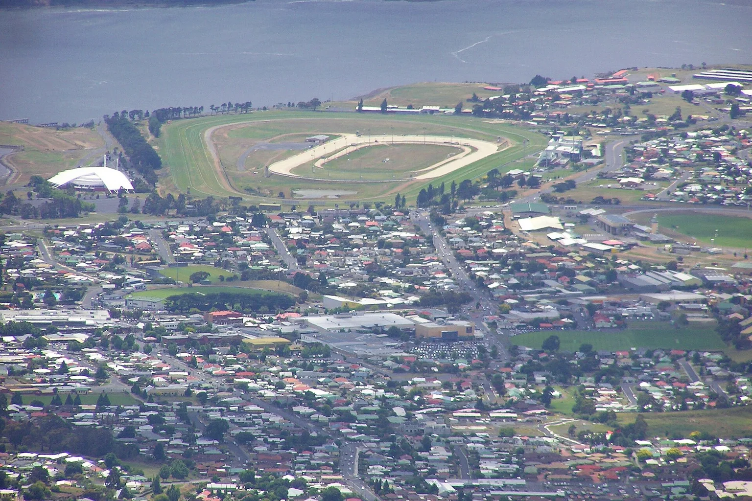 Aerial view of Glenorchy's houses and racecourse beside the River Derwent in Hobart, Tasmania