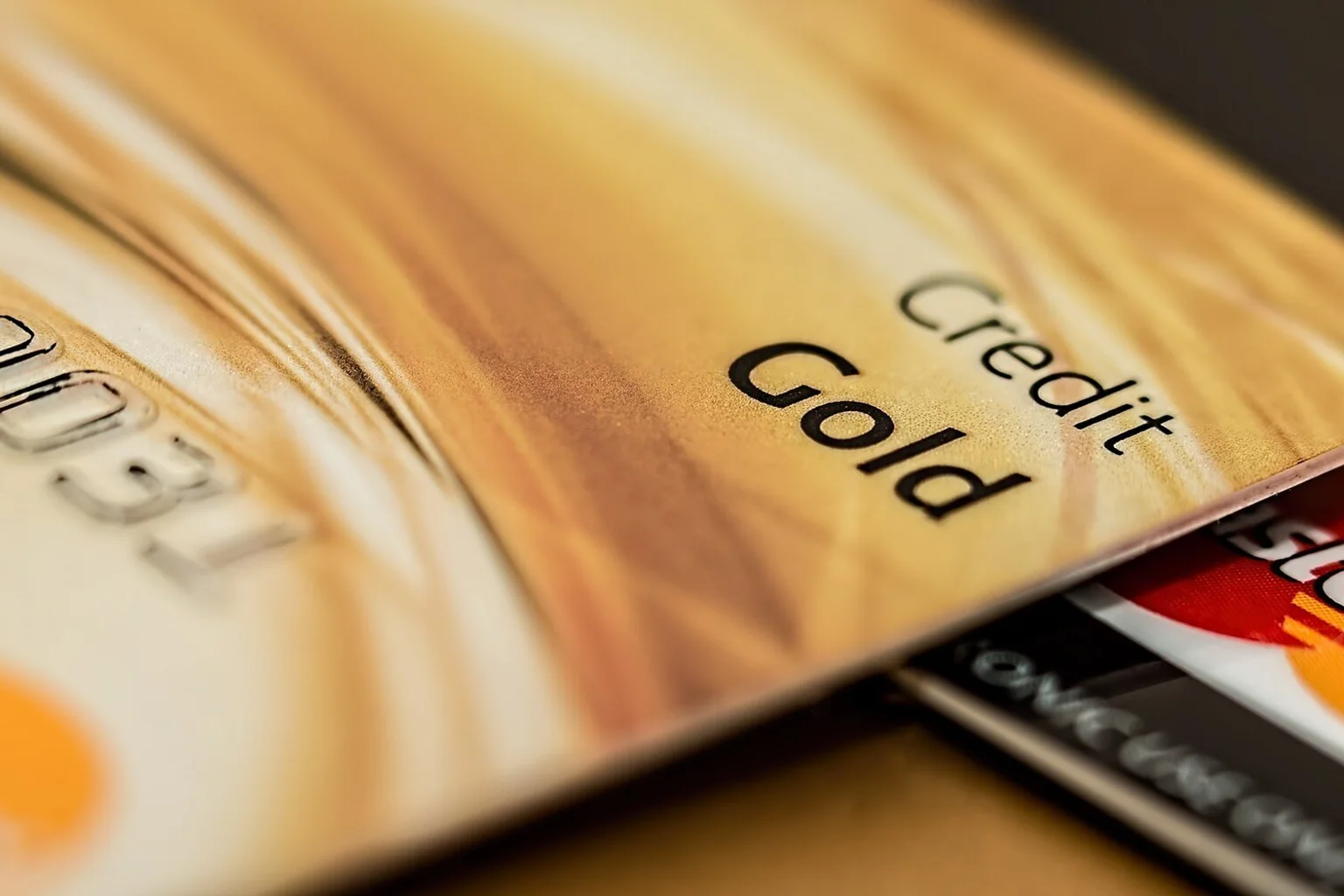 Close-up of a gold credit card resting against a Mastercard