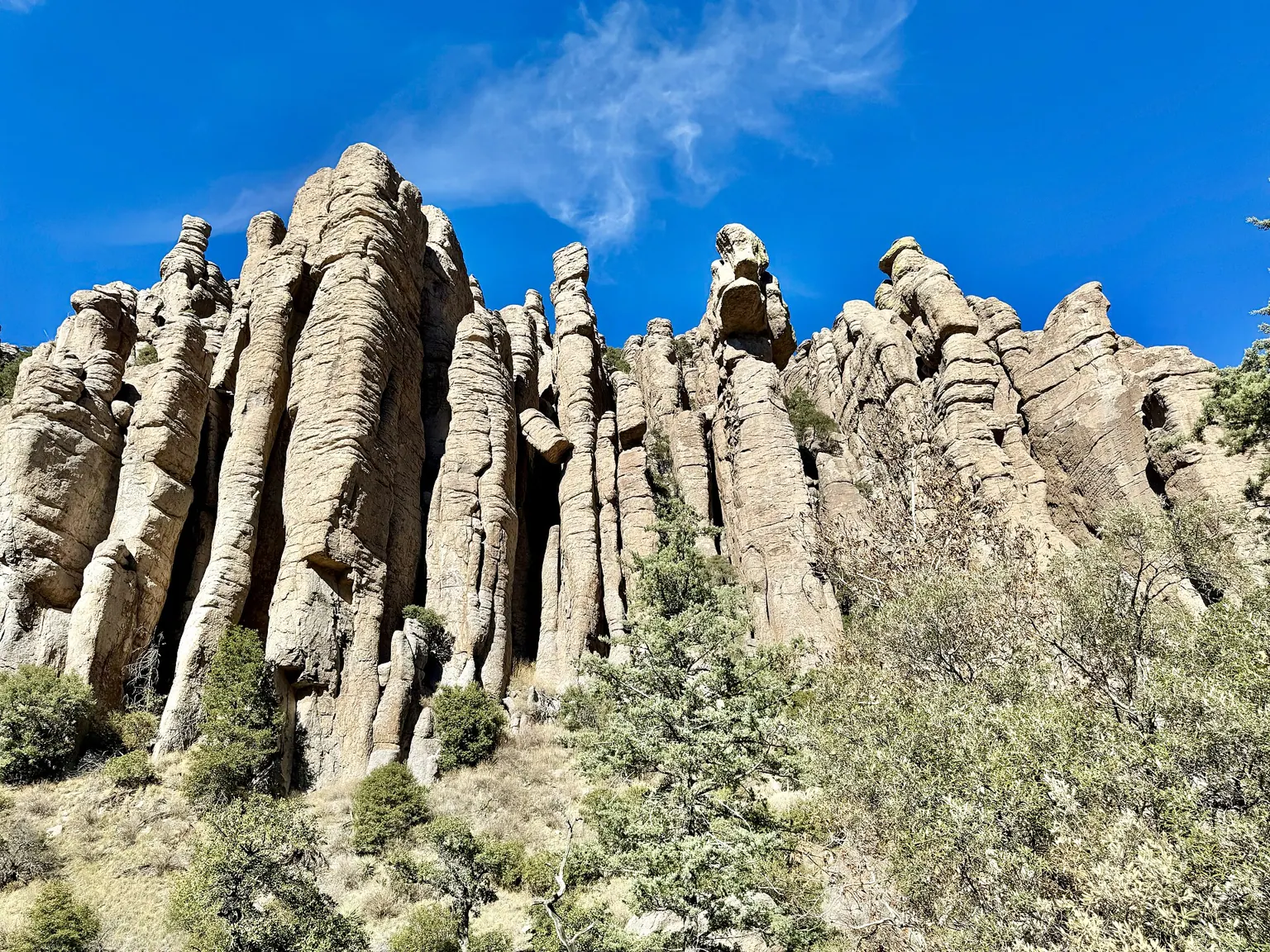 Tall columns of pale rock standing side by side like organ pipes under a deep blue sky.